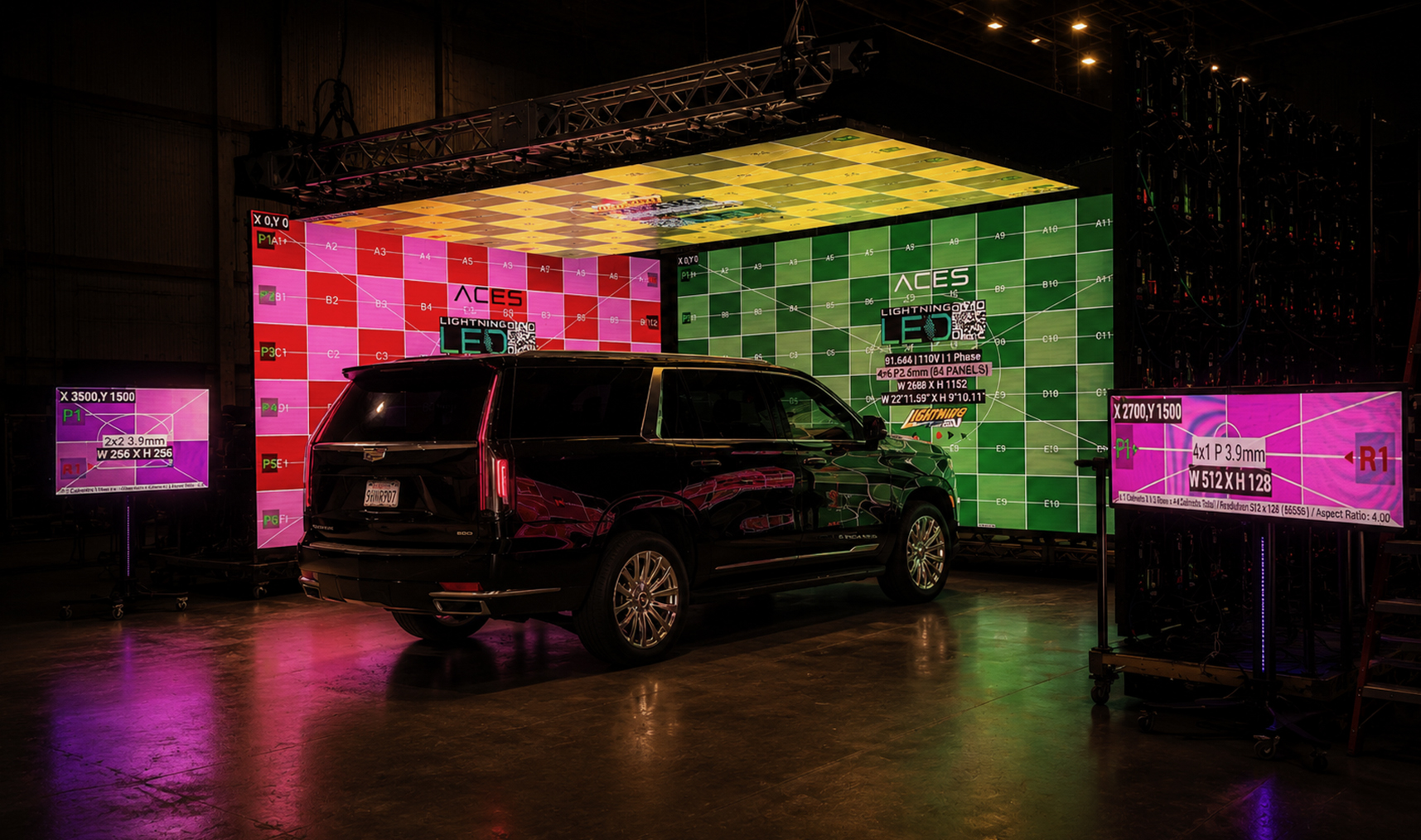 SUV in front of modular LED walls and production equipment.
