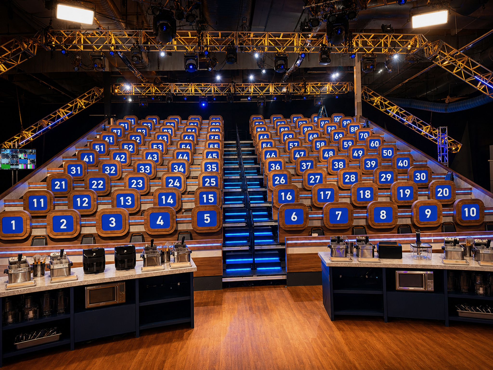 Game show set with numbered audience stations and lighting truss.